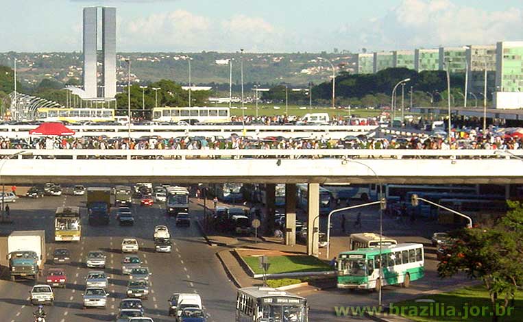 Plataforma Rodoviária de Brasília repleta de pessoas, em fim de tarde ensolarado de um dia normal