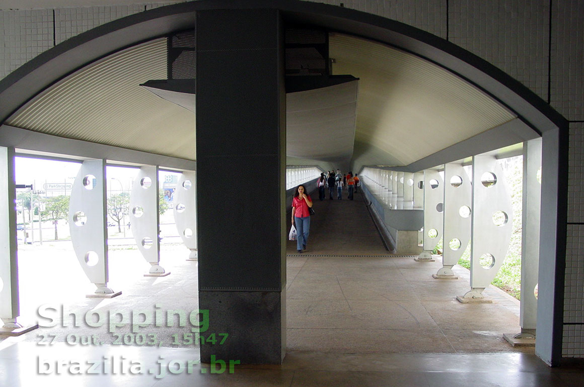 Passarela de pedestres sobre a via EPIA vista do saguão de guichês e bloqueios da Estação Shopping do Metrô de Brasília