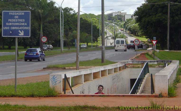 Placa obrigando o pedestre a fazer a travessia do Eixo Rodoviário pelas passarelas subterrâneas